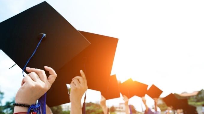 photo of students holding up their graduation caps